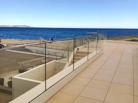 Barandilla de cristal en una terraza frente al mar