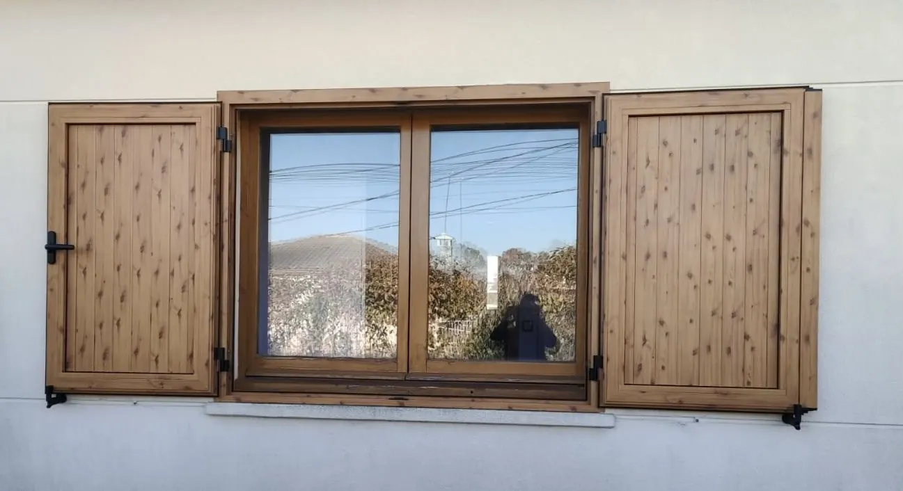 Ventana con acabado de madera y contraventanas